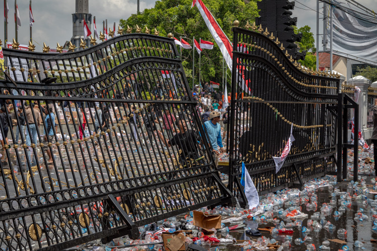 Protesters throw water bottles and stones on Aug. 13 at the official residence of Pati Regent Sudewo during a protest.