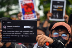 Students display posters with a tweet of President Prabowo Subianto reading “Rallies are part of democracy guaranteed by law“ during a protest against a revision to the Indonesian Military (TNI) Law in Surabaya, East Java, on March 24, 2025.