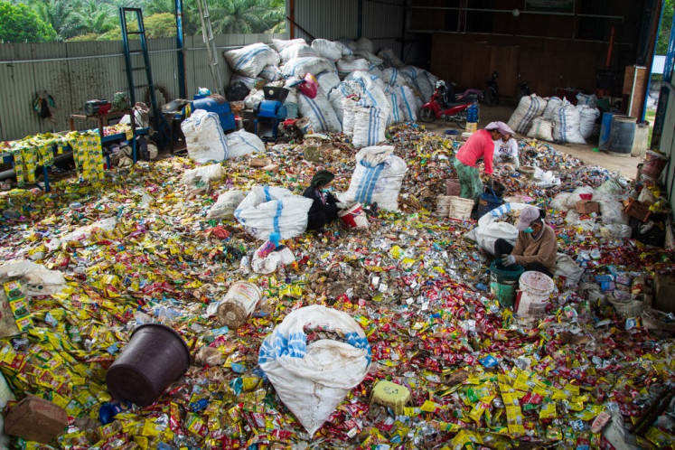Women sort plastic waste as a raw material for producing Petasol on Aug. 8 in Pekanbaru, Riau. Petasol is a diesel-equivalent fuel developed by the National Research and Innovation Agency (BRIN) and deployed at over 50 sites nationwide to support sustainable energy and plastic waste management.