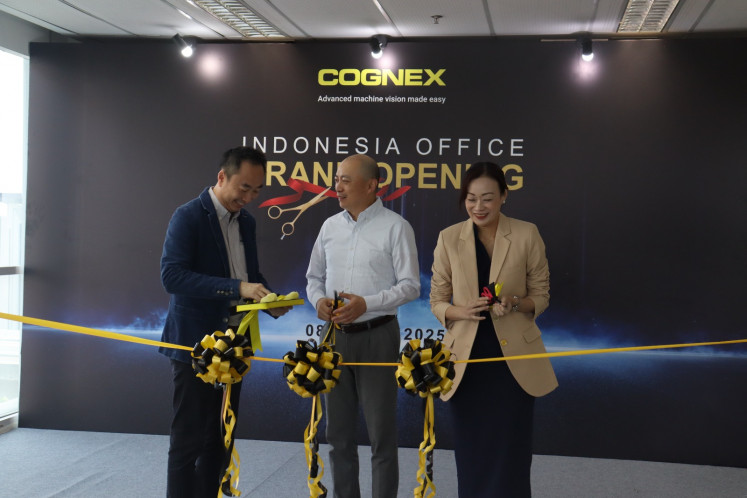 Inaugural snip: Cognex Corporation's vice president of sales in Asia,  Michael Zhu (center), flanked by area sales manager for ASEAN South, Chong Siong Chuang (left) and senior employee services manager for ASEAN and India, Shelina Quek, cut the ribbon on Wednesday during a ceremony to open the industrial machine vision maker's new office in Bekasi, West Java. The American company aims to provide machine vision automation equipment and solutions to food and beverage, automotive, electronics, logistics and pharmaceuticals manufacturers.