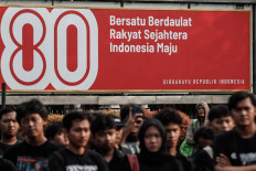 Human rights activists participate in the 873rd Kamisan rally on Aug. 14, 2025, in front of a banner celebrating the 80th anniversary of Indonesia’s independence near the State Palace in Central Jakarta. Held every Thursday since 2007, the Kamisan highlights past human rights violations, such as those that occurred during then-president Soeharto’s New Order regime.