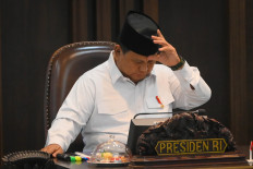 President Prabowo Subianto sets his kopiah (traditional male hat) ahead of a plenary cabinet meeting at a presidential office at the Presidential Palace in Jakarta on Aug. 6, 2025.