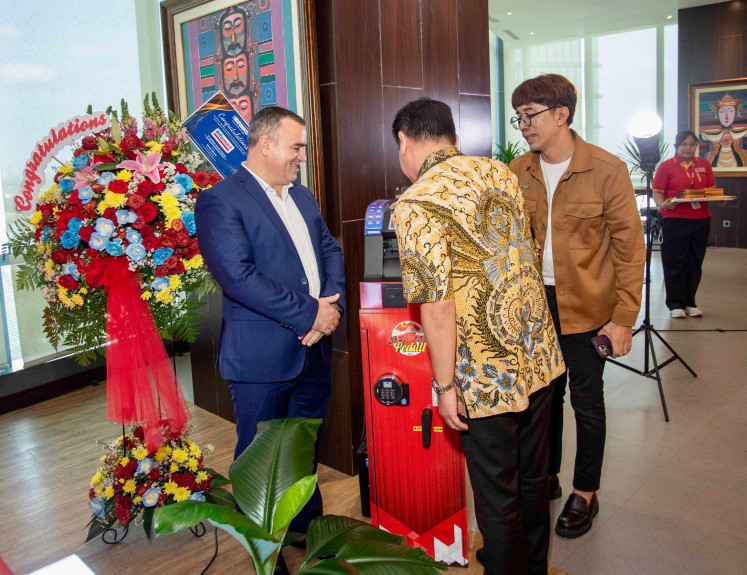 Retail chain Alfamart president director Anggara Hans Prawira (center) observes a Digital Retail Solution machine while cash and valuables management solution provider Brink’s Indonesia president director David Maksud (left) looks on. Brink's Indonesia has deployed the 1000th DRS machine for Alfamart.  