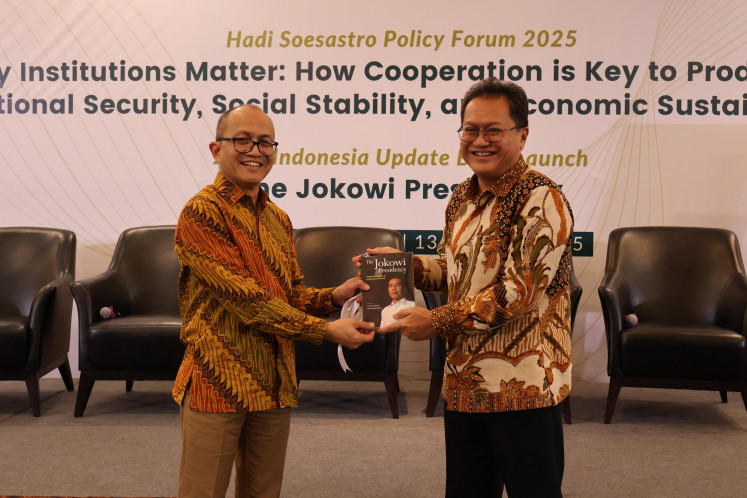 Arianto Patunru, policy engagement coordinator of the ANU Indonesia Project and a fellow at the ANU Arndt-Corden Department of Economics, presents “The Jokowi Presidency” to Yose Rizal Damuri, executive director of the Jakarta-based Centre for Strategic and International Studies (CSIS), during the book’s launch at the CSIS Auditorium, Jakarta, on Aug. 13, 2025.