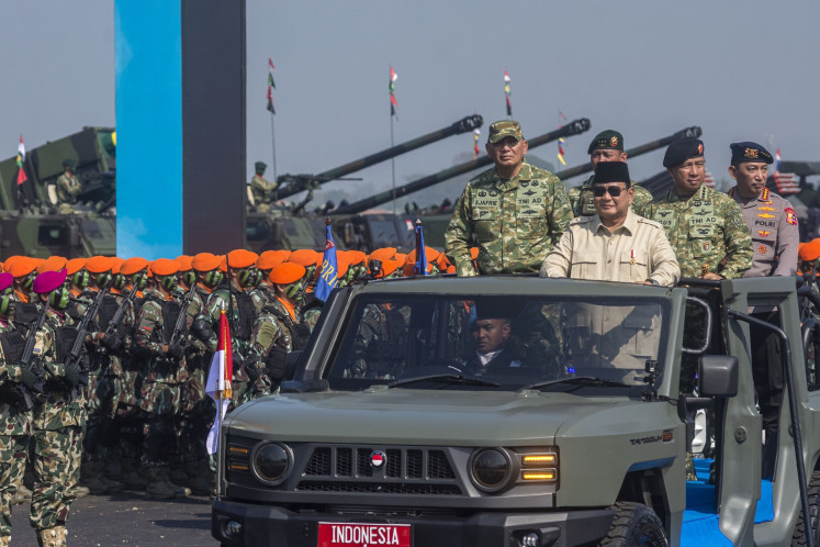 President Prabowo Subianto (second left) rides an open-top car with Defense Minister Sjafrie Sjamsoeddin (left), Indonesian Military (TNI) commander Gen. Agus Subiyanto (second right) and National Police chief Listyo Sigit Prabowo (right) to inspect troops on Aug. 10 during the Operational Troops and Military Honors ceremony at the Suparlan Airfield in Bandung, West Java.