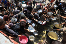 Palestinians wait to receive food from a charity kitchen in Gaza City on Aug. 15, 2025.