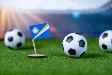An illustration of the Marshall Islands flag next to a soccer ball.