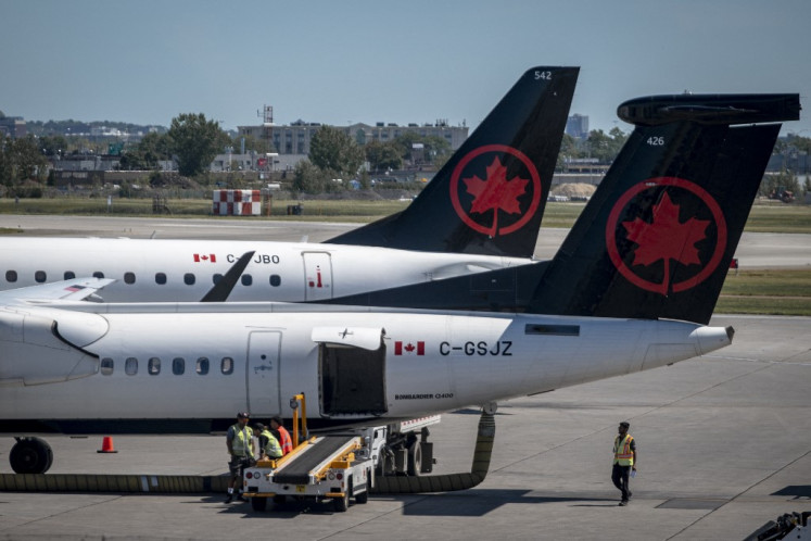 Two Air Canada planes stand on the tarmac of Pierre-Elliott Trudeau Airport in Montreal, Quebec, Canada, on Aug. 15, 2025. Air Canada's flight attendants went on strike Saturday, as the airline announced a complete shutdown of operations, creating summer travel chaos for its 130,000 daily passengers. 