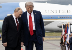 US President Donald Trump (right) and Russian President Vladimir Putin pose on a podium on the tarmac after they arrived at Joint Base Elmendorf-Richardson in Anchorage, Alaska on August 15, 2025.