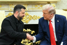 Ukrainian President Volodymyr Zelensky and US President Donald Trump shake hands during a meeting in the Oval Office of the White House in Washington, DC, on August 18, 2025.