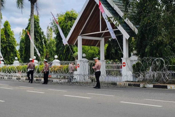 Police officers stand guard in front of Bone regency office in South Sulawesi, on Aug. 19, 2025, before a rally in protest at a property tax hike.