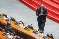 Constitutional Court justice-elect Inosentius Samsul (right) greets lawmakers during the House of Representatives plenary meeting at the Senayan legislative complex in Jakarta on Aug. 21, 2025.