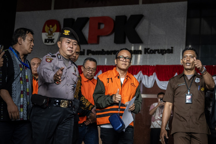 Deputy Manpower Minister and graft suspect Immanuel Ebenezer (second right) walks to a prisoner transfer van on Aug. 22 at the Corruption Eradication Commission (KPK) headquarters in Jakarta.