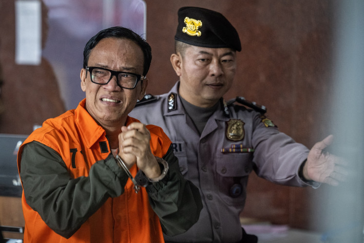 Then-deputy manpower minister and graft suspect Immanuel Ebenezer (left) cries while walking to the press conference room at the Corruption Eradication Commission (KPK) headquarters in Jakarta on Aug. 22, 2025. The antigraft body named the deputy minister and 10 other people as suspects in an alleged extortion case pertaining to the issuance of occupational health and safety (K3) certification at the Manpower Ministry.