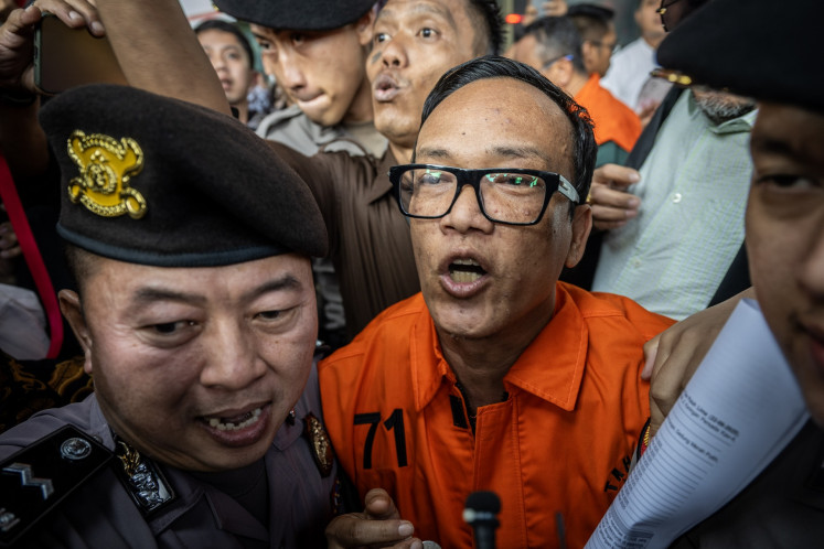 Deputy Manpower Minister and graft suspect Immanuel Ebenezer (center) walks to a prisoner transfer van at the Corruption Eradication Commission (KPK) headquarters in Jakarta on Aug. 22, 2025. The antigraft body name the deputy minister and 10 other people as suspects in an alleged extortion case pertaining to the issuance of the occupational health and safety (K3) certification at the Manpower Ministry.