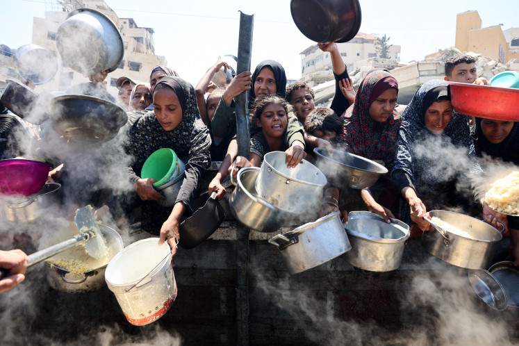 Palestinian women and girls elbow their way to receive cooked rice from charity kitchen in Gaza City on August 23, 2025. The United Nations officially declared a famine in Gaza on August 22, blaming “systematic obstruction“ of aid by Israel during more than 22 months of war, with Prime Minister Benjamin Netanyahu swiftly dismissing the findings.