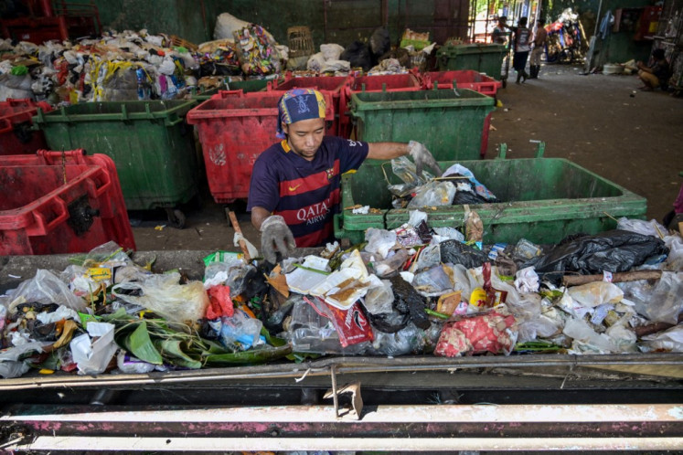 A worker gathers plastic waste on June 17 at a depot in Surabaya, East Java.