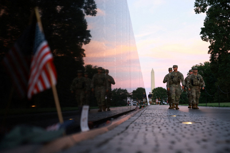 Members of the National Guard walk through the Vietnam Veterans Memorial on the National Mall after US President Donald Trump deployed the National Guard and ordered an increased presence of federal law enforcement to assist in crime prevention, in Washington, D.C. on August 23, 2025.
