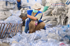 A worker gathers used plastic bottle to be recycled at the Bali PET Recycle facility in Denpasar, Bali on Aug. 22, 2025.