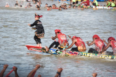 Rayyan Arkan Dikha (left), an 11-year-old boy who went viral for his calm dance on the bow of a traditional longboat, performs during the Pacu Jalur longboat race festival on the Kuantan River in Kuantan Singingi regency, Riau province on August 22, 2025. Armed with colorful oars, rowers pack into long boats in western Indonesia, paddling furiously in front of race crowds swelled by the viral success of a young boy famous for his dancing at the front of the traditional vessels.