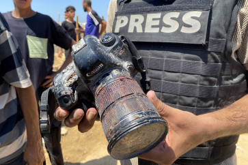 A journalist holds the blood-covered camera belonging to Palestinian photojournalist Mariam Dagga, a journalist who freelanced for AP since the start of the war and who was killed in an Israeli strike on Nasser hospital in Khan Yunis in the southern Gaza Strip, during her funeral on August 25, 2025. Gaza's civil defense agency said five journalists, including Mariam Dagga, were among at least 20 people killed on August 25 when Israeli strikes hit Nasser hospital in the south, with Reuters, the Associated Press and Al Jazeera mourning their slain contributors.