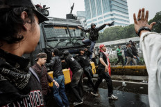 Protesters try to block a police water cannon vehicle during their demonstration on Aug. 25 demanding the dissolution of parliament on a street in front of the House of Representatives building in Jakarta.