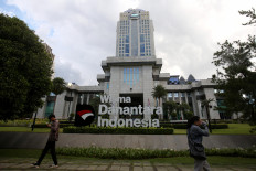 Residents pass by the headquarters of state asset fund Danantara on July 1 in South Jakarta.