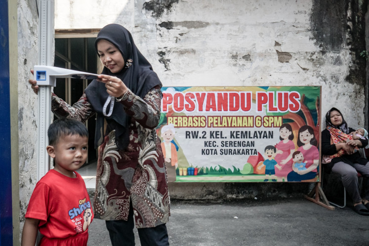 A health worker measures a child's height during the launching of an integrated health post (posyandu) on Aug. 11 in Surakarta, Central Java.