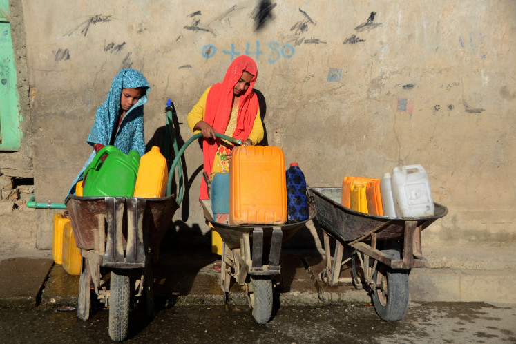 Girls fill containers with drinking water from a tap in Kandahar on May 24, 2022. More than two billion people worldwide still lack access to safely-managed drinking water, the United Nations said on August 26, 2025, warning that progress towards universal coverage was moving nowhere near quickly enough.