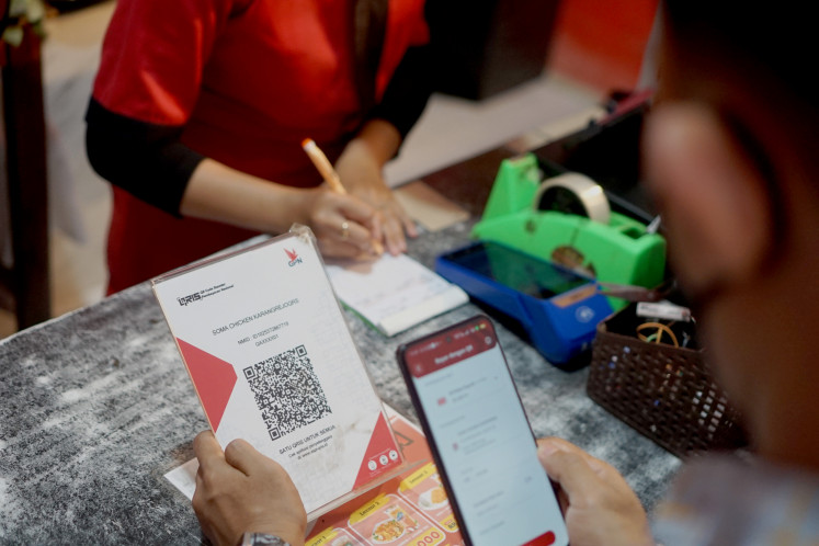 Residents make payments using QRIS (Quick Response Code Indonesia Standard) at a  merchant in Tulungagung, East Java, on August 21, 2025.