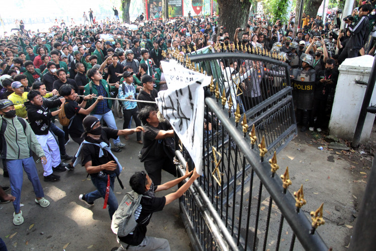 Protesters tear down the gate of the North Sumatra Regional Legislative Council (DPRD) building in Medan during a demonstration on Aug. 26, 2025. The rally called for an end to excessive salaries for members of the House of Representatives.