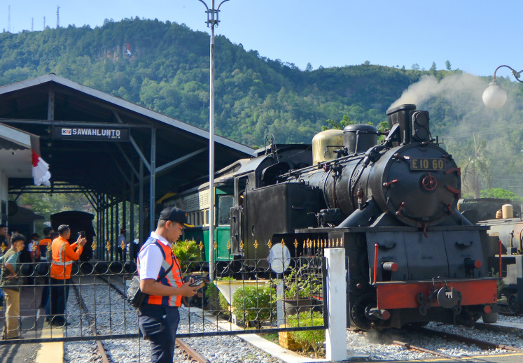 The E1060 “Mak Itam” locomotive carries tourists in Sawahlunto, West Sumatra, on Aug. 26, 2025. The German-made steam locomotive is being reused to transport tourists, but it is not operational and can only be driven by a BB 303 diesel locomotive. 
