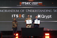 Patrick Dannacher (center), president director of ITSEC Asia, and Kevin Chalker (right), CEO and founder of Qrypt, hold up copies of the memorandum of understanding they signed on Aug. 27 during the ITSEC Cybersecurity Summit 2025 at The Ritz-Carlton Jakarta in the Mega Kuningan business district in South Jakarta. (Courtesy of ITSEC Asia)