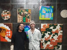 Creative pulse: Popomangun (left) and Low Moromi pose with their artworks on Aug. 19, 2025, at LQID Creative Space, a mini gallery at the Sudirman 7.8 Building in Jakarta. The second piece from the left, displayed above them, is their collaborative work titled after the exhibition’s theme, "Organic Rhythm".
JP/Nur Janti