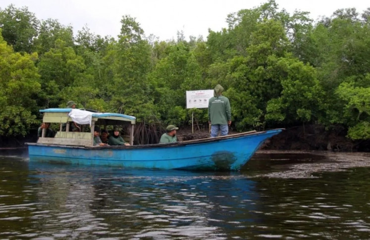 Green patrol: Mangrove conservationists conduct a riverine patrol on April 12, 2025 at the Teluk Pambang mangrove forest in Bengkalis regency, Riau.