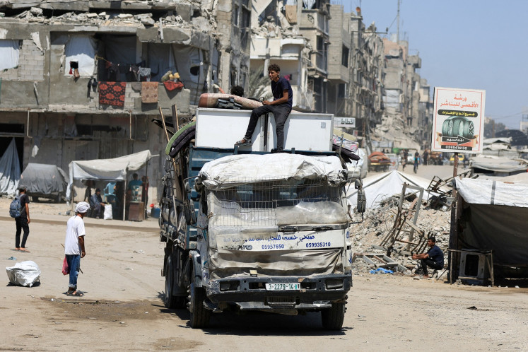 Displaced Palestinians ride on a vehicle loaded with belongings as they flee from one area to another within Gaza City amid an Israeli military operation in Gaza on Aug. 29, 2025.