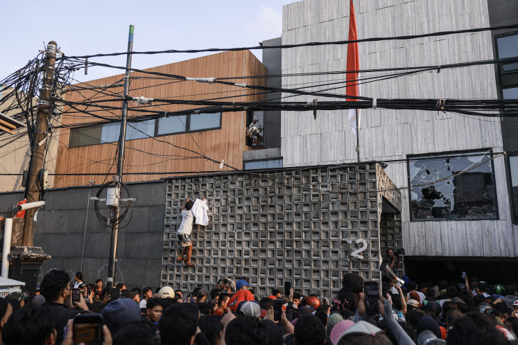 A crowd of people gather on Aug. 30, 2025, at the private residence of Ahmad Sahroni in Tanjung Priok, North Jakarta. The home of the House of Representatives lawmaker from the NasDem Party was reportedly broken into and looted as violence escalates in the ongoing protests against legislators’ perks and police brutality.