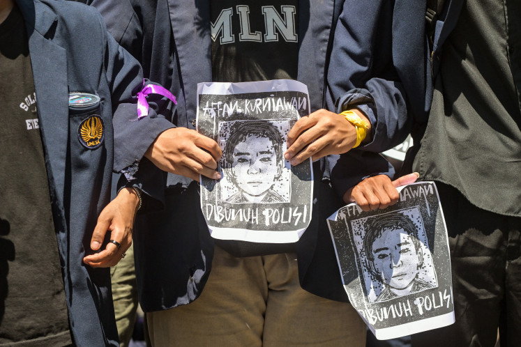 Demonstrators hold portraits of Affan Kurniawan, a motorcycle taxi (ojol) driver who was run over by a police Mobile Brigade (Brimob) tactical vehicle on Aug. 28 in Jakarta, during a protest on Aug. 30 in front of Surabaya Police headquarters in East Java.