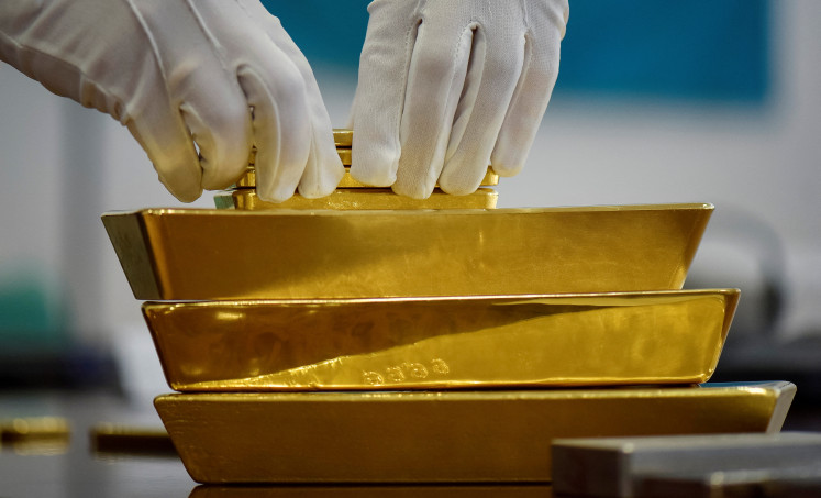 An employee places gold bars in the Kazakhstan's National Bank vault in Almaty on Sept. 30, 2016.