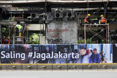 Workers clear debris at a burned-out bus stop in Jakarta on Sept. 2, 2025, following protests over police brutality and lawmakers’ excessive pay.
