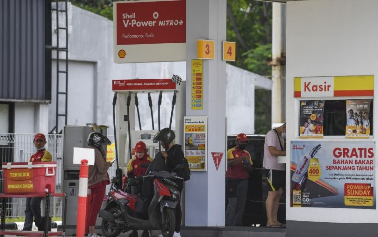 An employee fills a customer's vehicle on March 9, 2023, with fuel at a Shell gas station in Jakarta.