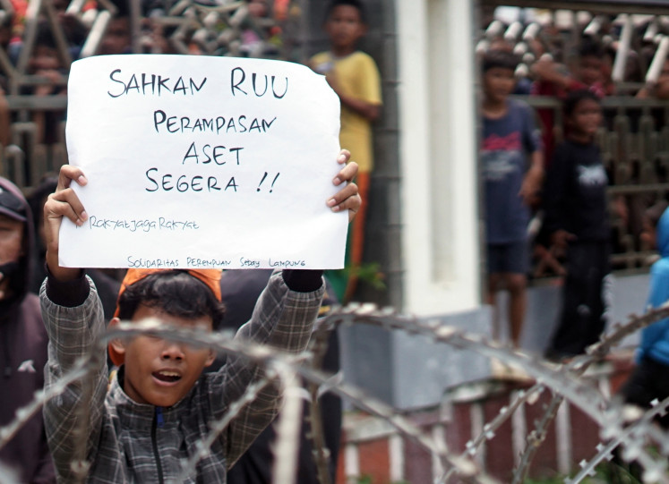 A protester holds a banner calling for the passage of the asset forfeiture bill during a protest at the Lampung Provincial Legislative Council (DPRD) in Bandar Lampung, Lampung, on Sept. 1, 2025. During the protest, rallygoers urge the government to pass the long-awaited asset bill and improve welfare for teachers and lecturers in the country, as well as for the legislature to cut lavish allowances for lawmakers.