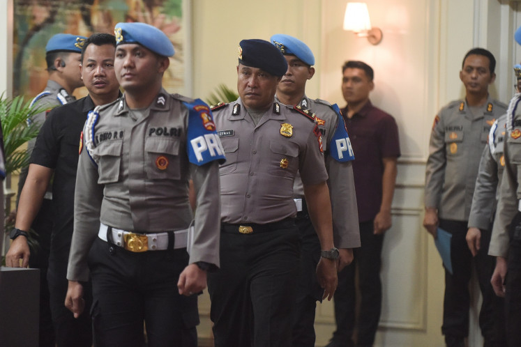 Comr. Kosmas Kaju Gae (center), commander of the National Police Mobile Brigade's (Brimob) Fourth Pelopor Regiment Battalion A, is escorted out of the National Police's Transnational Crime Center building in Jakarta on Sept. 3, 2025. An ethics hearing dishonorably discharged Kosmas after finding him guilty of committing serious ethical violations that caused the killing of 21-year-old ojol (online motorcycle transportation driver) Affan Kurniawan during a violent protest in Jakarta on Aug. 28, 2025.