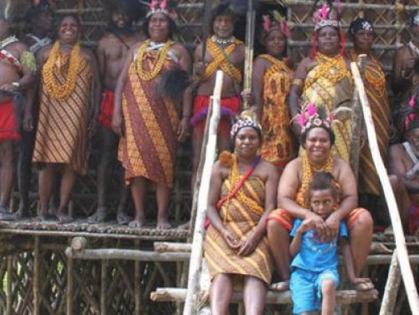 Women and men gather for a family photo in a traditional wooden house in Menyambouw district, Arfak Mountains regency, West Papua in this undated picture. 