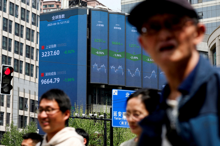 An electronic board shows Shanghai and Shenzhen stock indices in Shanghai, China, on April 16, 2025.