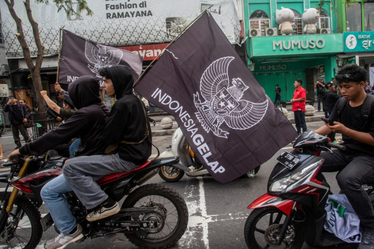 Protesters carry flags of the Indonesia Gelap (Dark Indonesia) movement on Sept. 1, 2025, during a student-led demonstration demanding police reform in Yogyakarta.