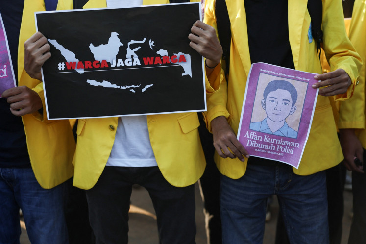 University students hold a poster at a rally on Sept. 4 outside the Senayan legislative complex in Jakarta that read #WargaJagaWarga (Citizens protect citizens) and a picture depicting Affan Kurniawan, a 21-year-old motorcycle ride-hailing driver who was killed after being run over by a police armored vehicle during protests over lawmakers' lavish pay and allowances on Aug. 28.
