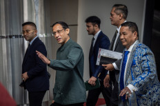 Former education, culture, research and technology minister Nadiem Makarim (second left) greets journalists upon entering the Attorney General's Office building in Jakarta on Sept. 4, 2025 for questioning as a witness in a corruption case pertaining to the procurement of Chromebook laptops for schools nationwide during his ministerial tenure.