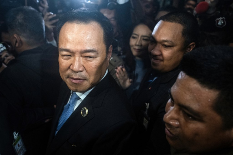 Bhumjaithai Party leader Anutin Charnvirakul (left) looks on as he leaves parliament following the announcement he had won most votes from MPs to become Thailand's next prime minister in Bangkok on September 5, 2025. 