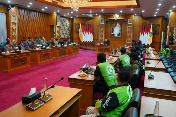 Bali Governor Wayan Koster (center) meets with online motorcycle taxi drivers on Aug. 31 at his official residence in Denpasar. Koster asked the drivers to stop their demonstration following riots in front of the Bali Police headquarters and the Bali Provincial Legislature Council to protest the murder of a driver on Aug. 28 in Jakarta by Mobile Brigade personnel.